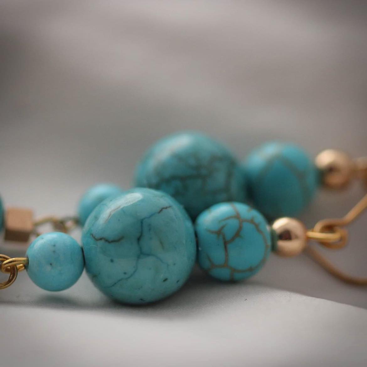 Arcana Vergoldete Ohrringe mit Türkisen, Hämatit und Howlith Steinen